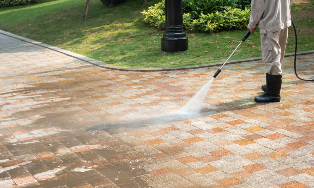 Cleaner pressure washing a concrete driveway