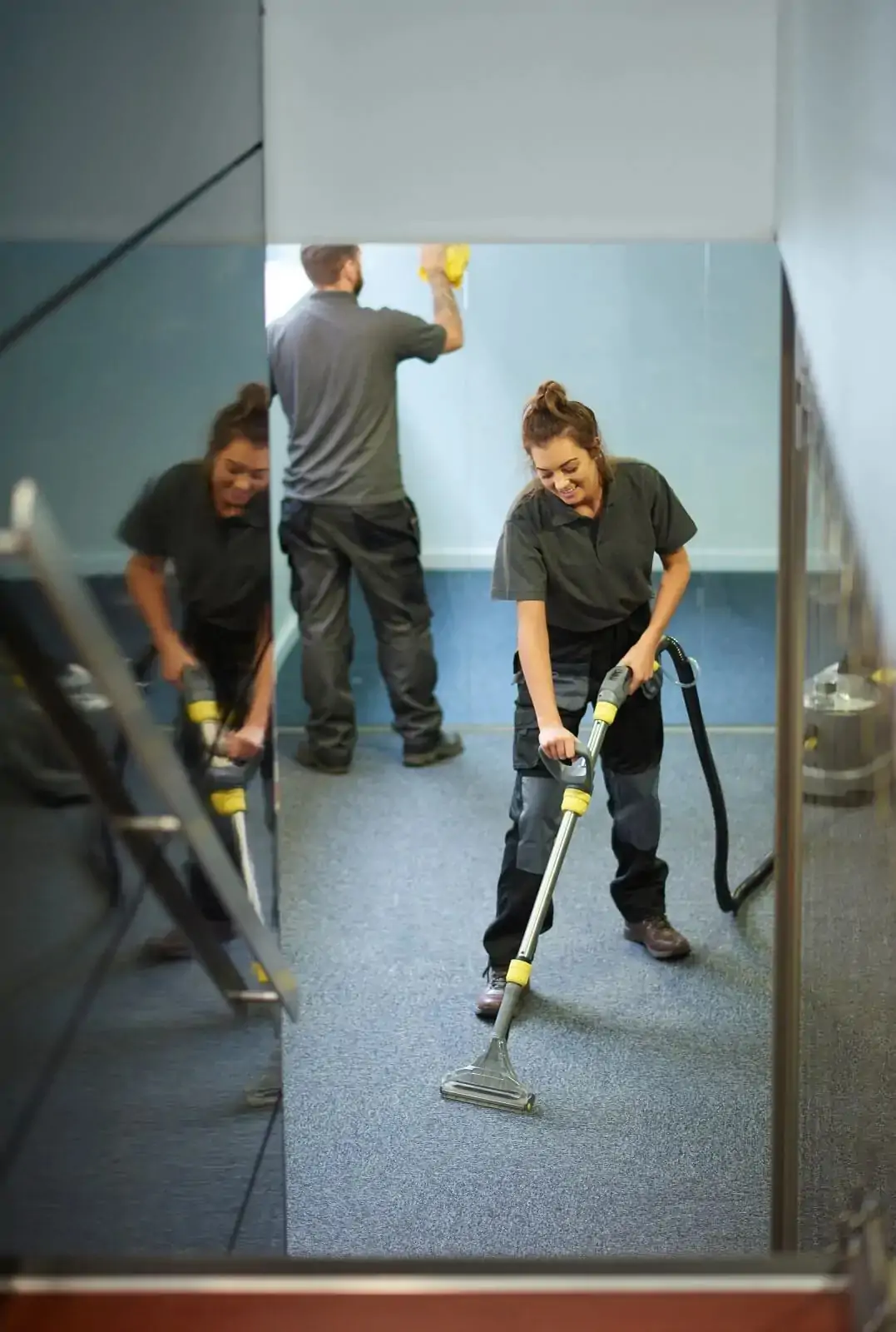 IMG_Industrial Cleaning A man and a woman vacuuming a floor.