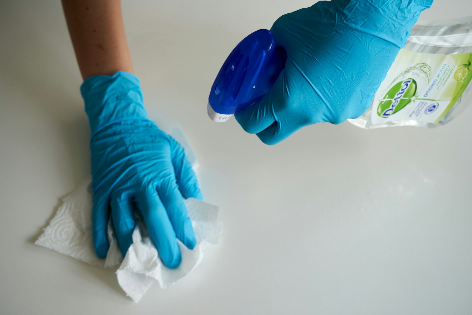Disinfecting a desk surface in an office Disinfecting a desk surface in an office